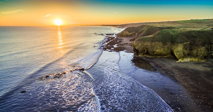 view of Durham Heritage coastline as the sun rises over the North Sea